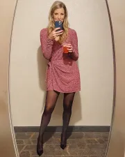 Julie allo specchio: abito rosa e calze nere